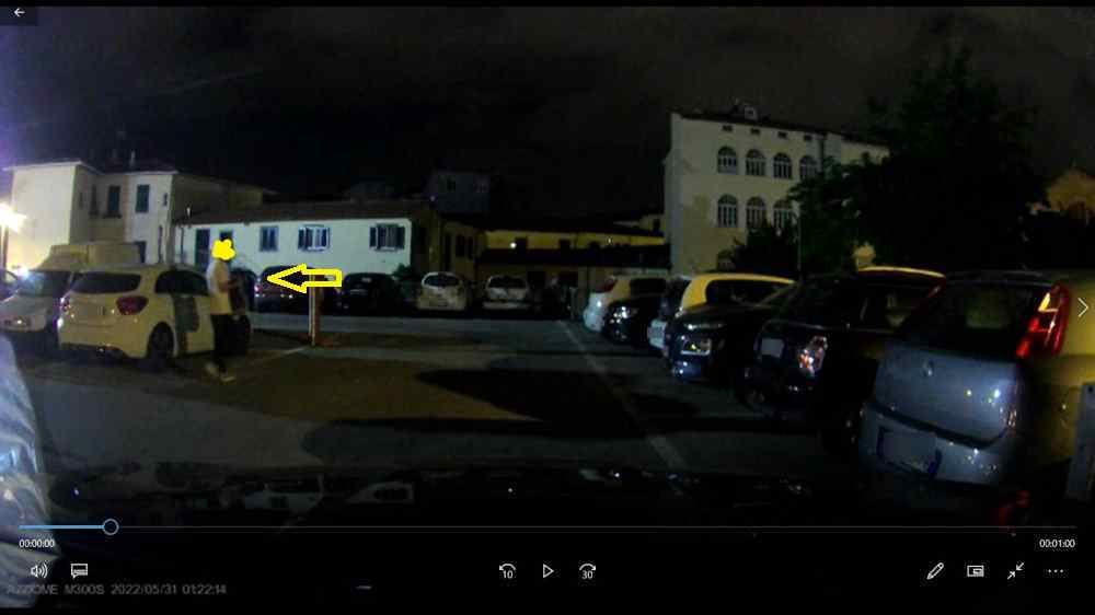 Un frame del video dove di vede un uomo che si aggira tra le auto alla ricerca di qualche cosa
