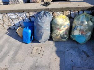 Mister Green da l'esempio e giovani 20enni lo aiutano, puliti gli scogli dietro la Baracchina Rossa