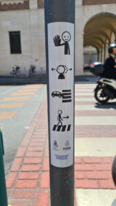 Disabilità, disegni e simboli CAA sui pali degli attraversamenti pedonali davanti alle scuole e in altri luoghi sensibili