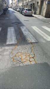 Borgo come via Ostiense, vernice gialla su dossi crepe e avvallamenti