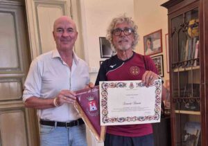 Salvetti premia Leonardo Tramonti per avere conquistato il primo posto nella mezza maratona di Lisbona 2025 over 70